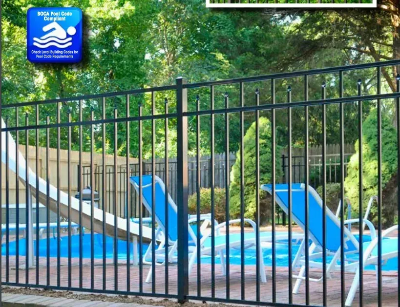 Black metal fence around a pool area with blue lounge chairs and a slide.