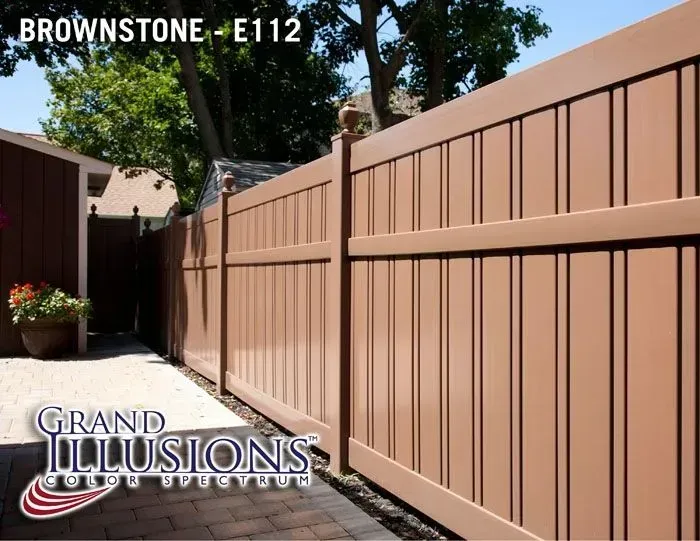 Brownstone-colored vinyl fence in a backyard setting.