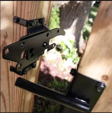 Black gate latch hardware mounted on wooden planks.