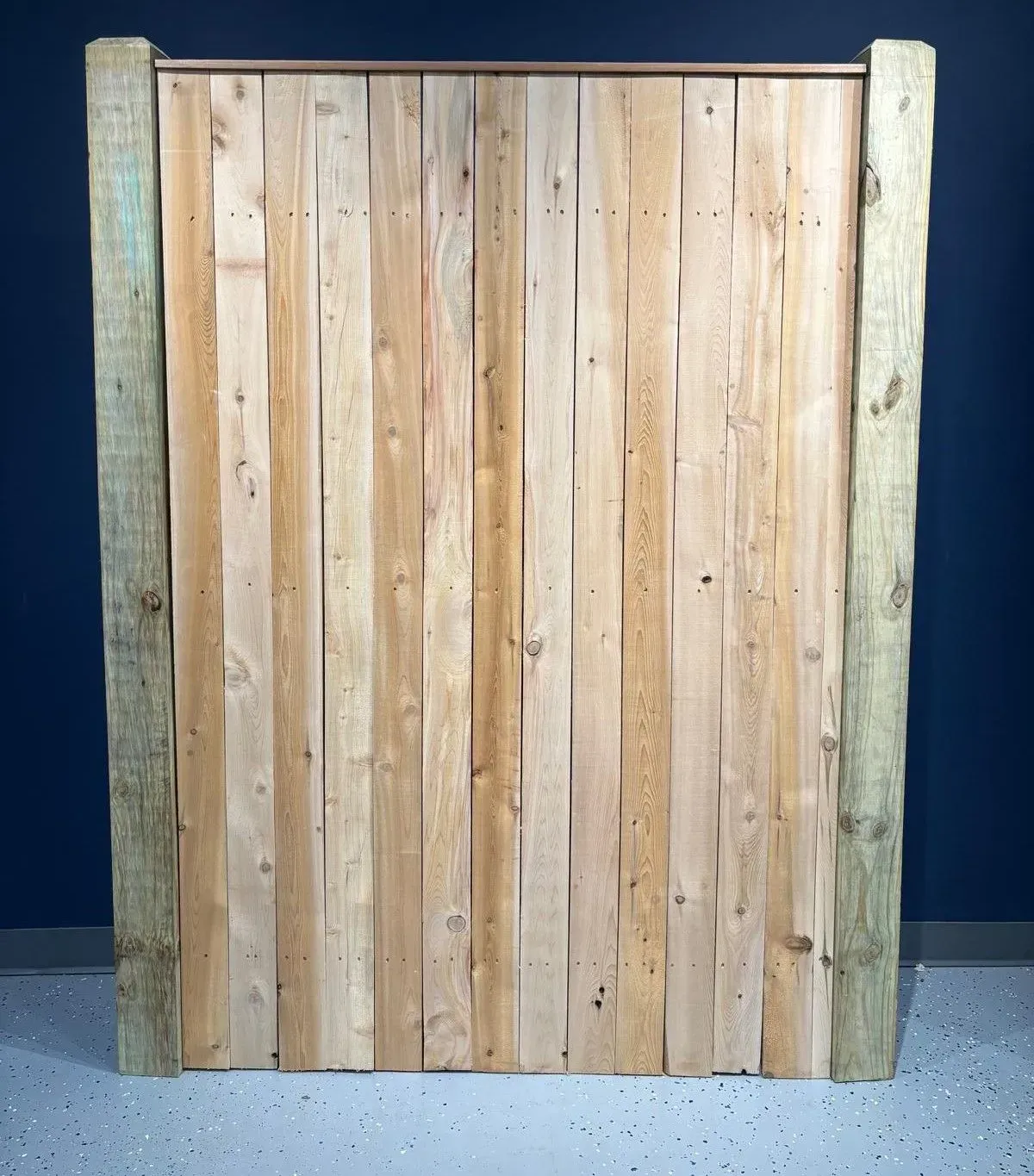 Wooden panel with vertical planks framed by green-tinged posts, and a metal bar across the top.