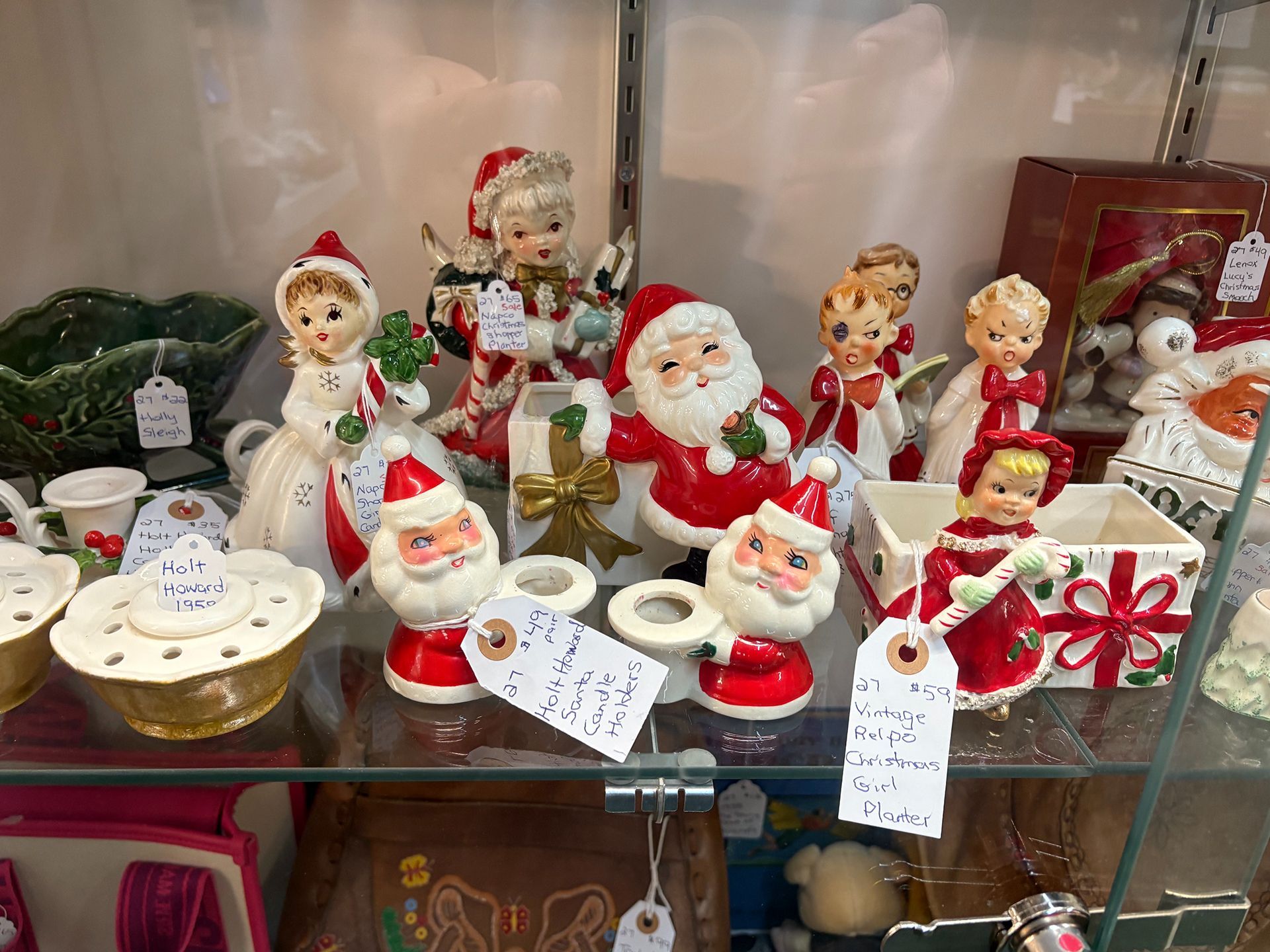 Shelf display of vintage Christmas figurines, including elves, angels, and
