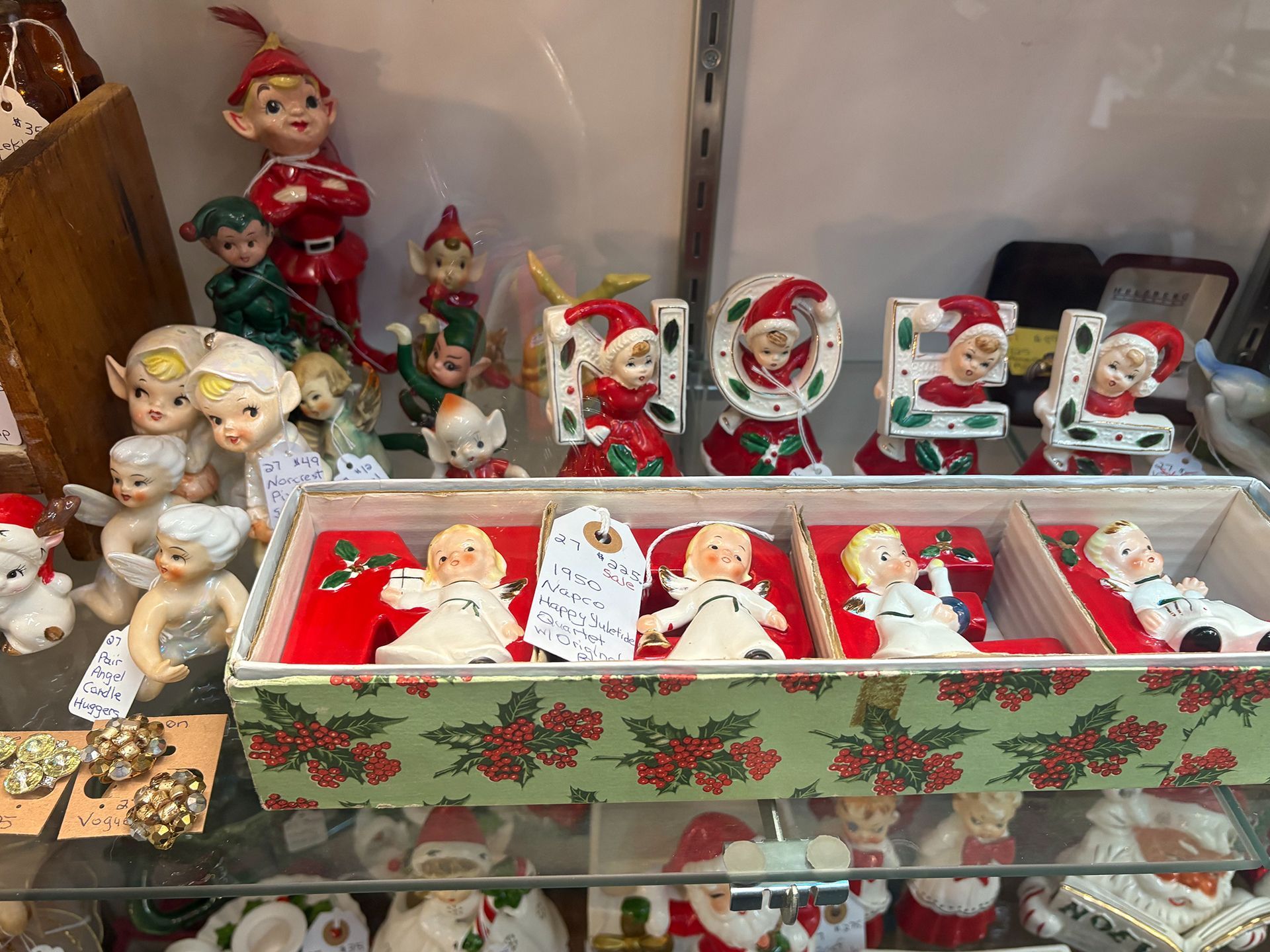 Glass display case with vintage Santa figurines and other items.