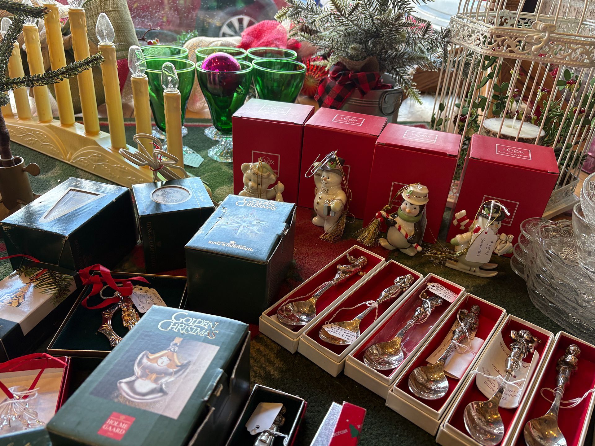Christmas decorations and gifts on display: angel figurines, spoons, boxes, candles, and glass.