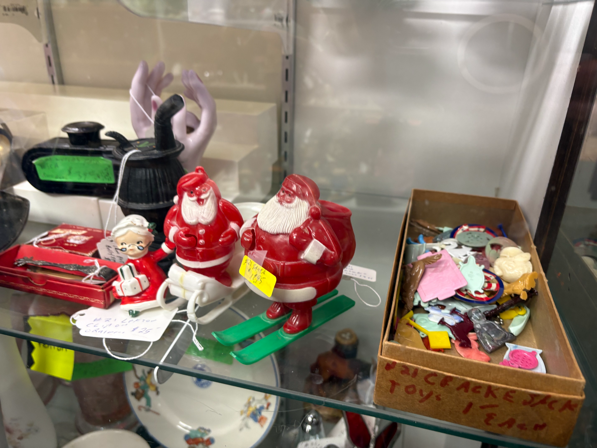 Shelved vintage Christmas figurines, Santa Claus, angels, children, red, white, in a shop display.