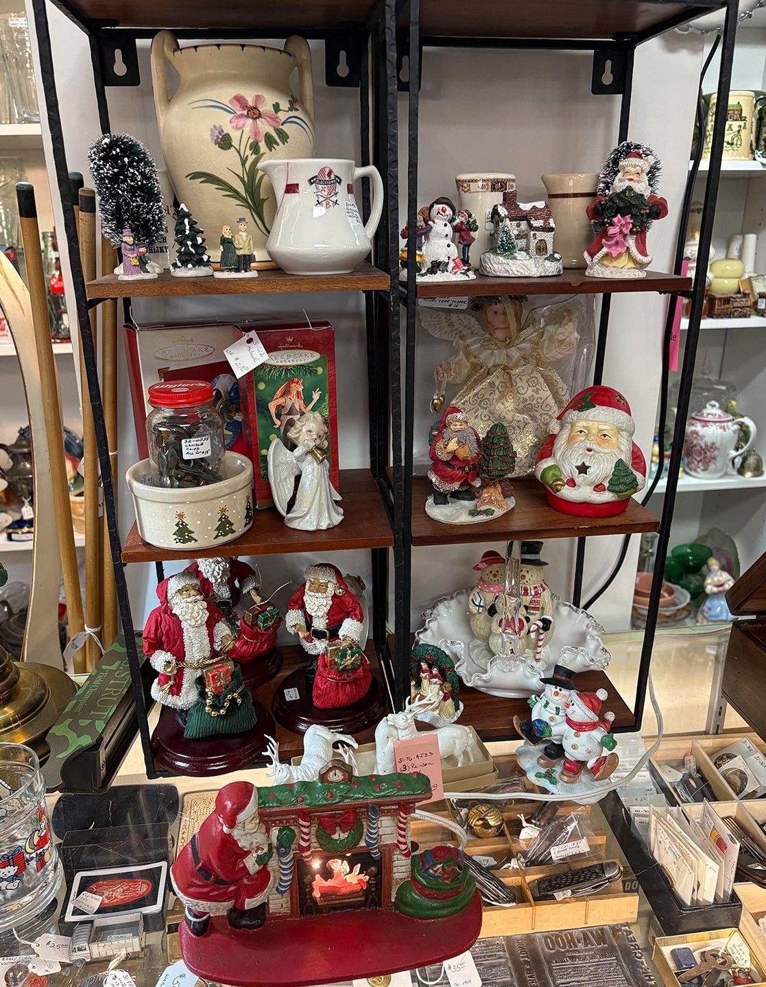 Shelves display vintage Christmas decorations, including Santas, figurines, and a floral vase.