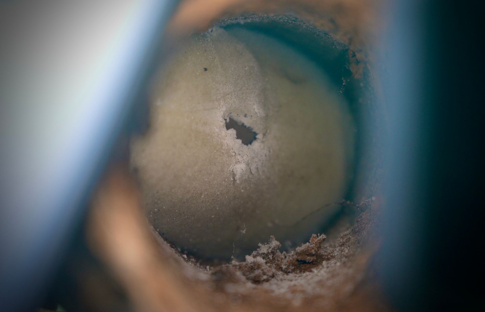 A close up of a hole in a piece of wood.