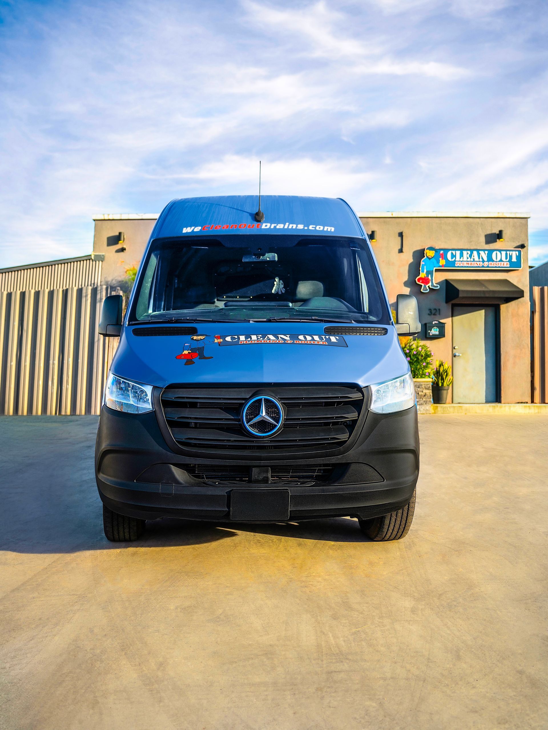 A blue van is parked in front of a building.