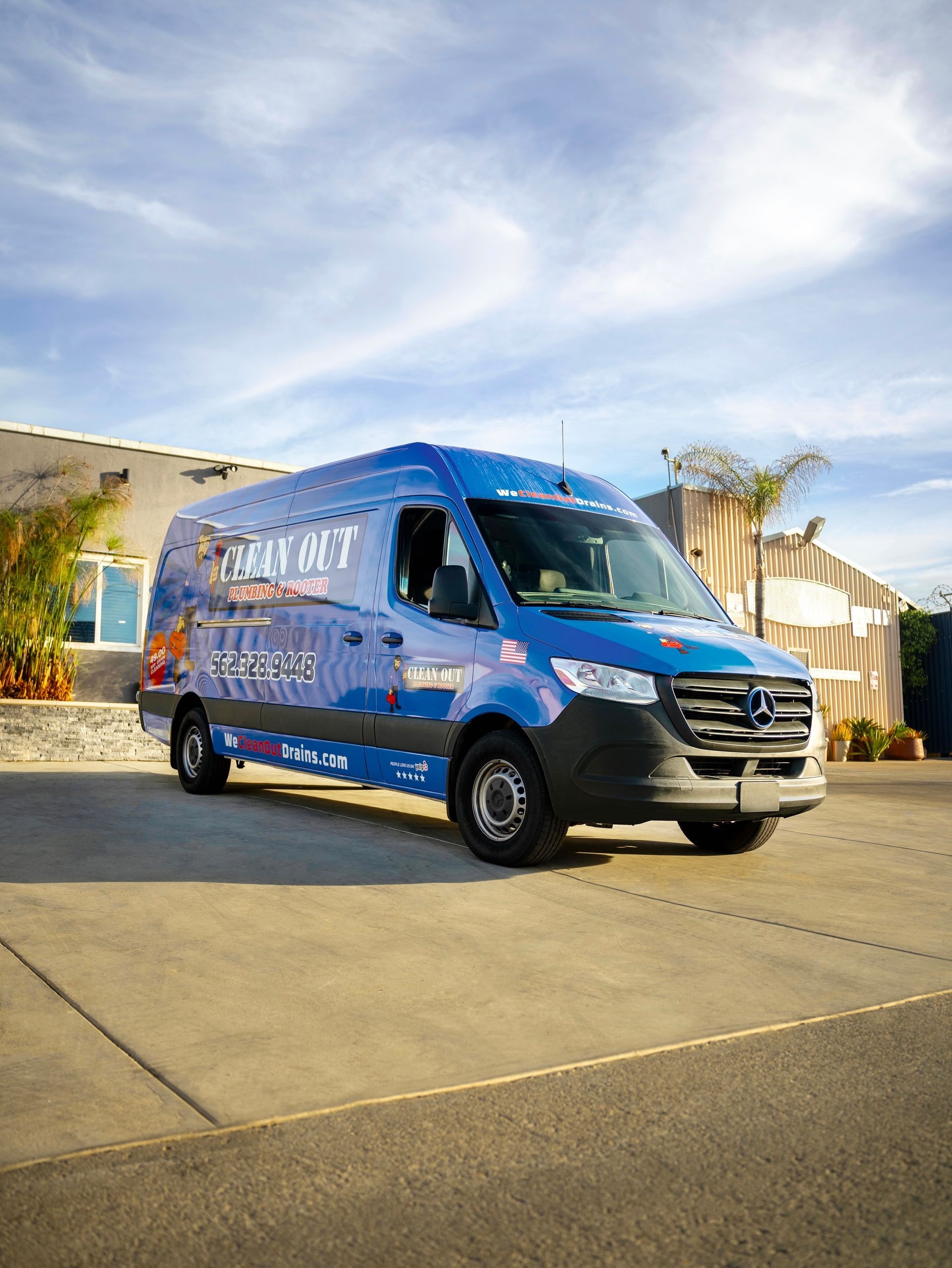 A blue van is parked in front of a building.