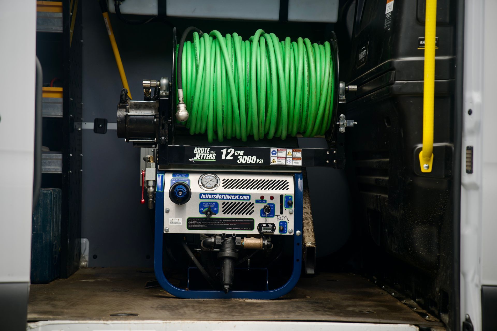 A hose reel is sitting in the back of a van.