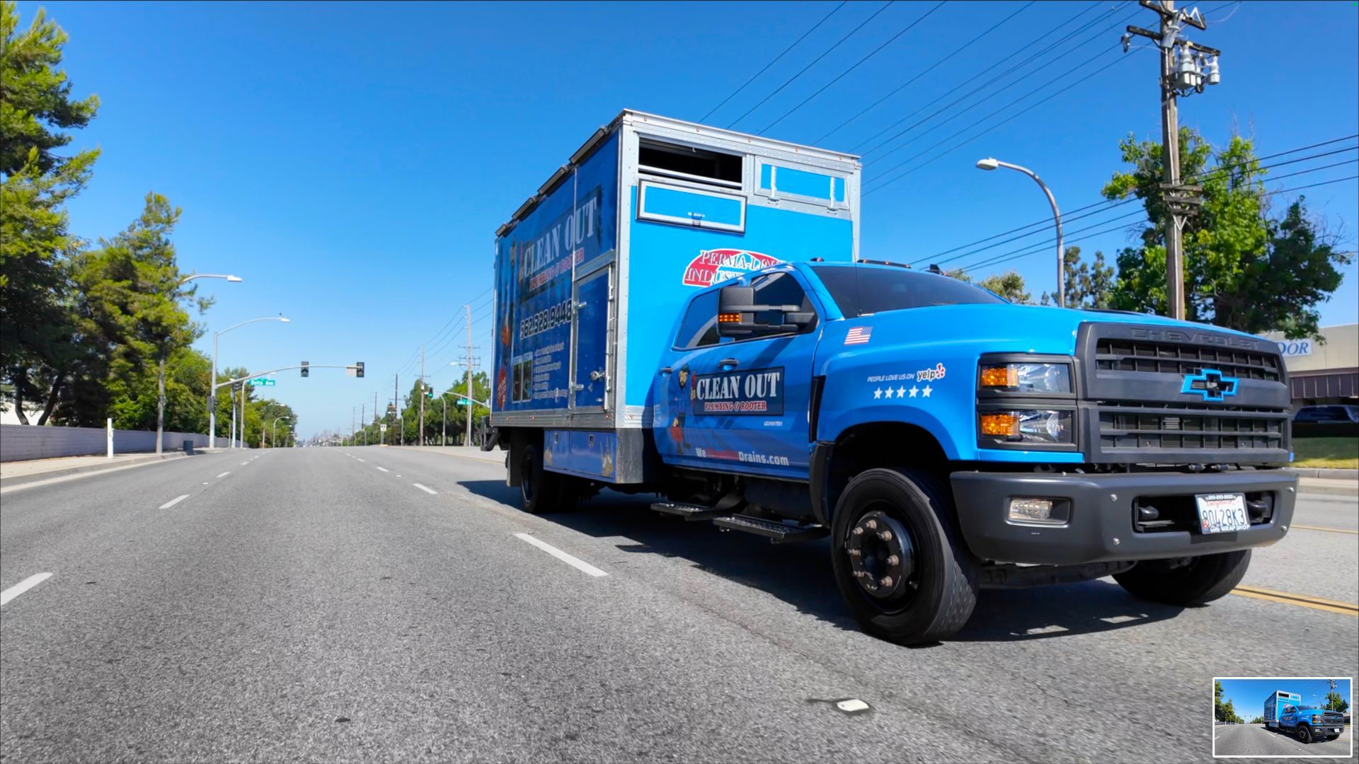 A blue truck is parked on the side of the road.