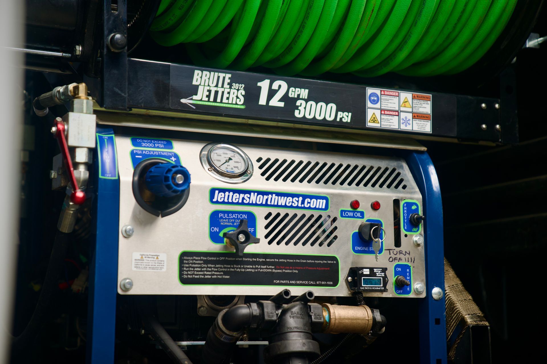 A blue and white machine with a green hose attached to it.