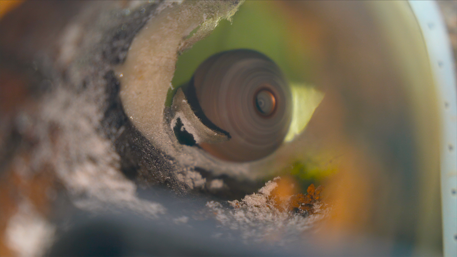 A close up of a machine cutting a hole in a piece of wood.