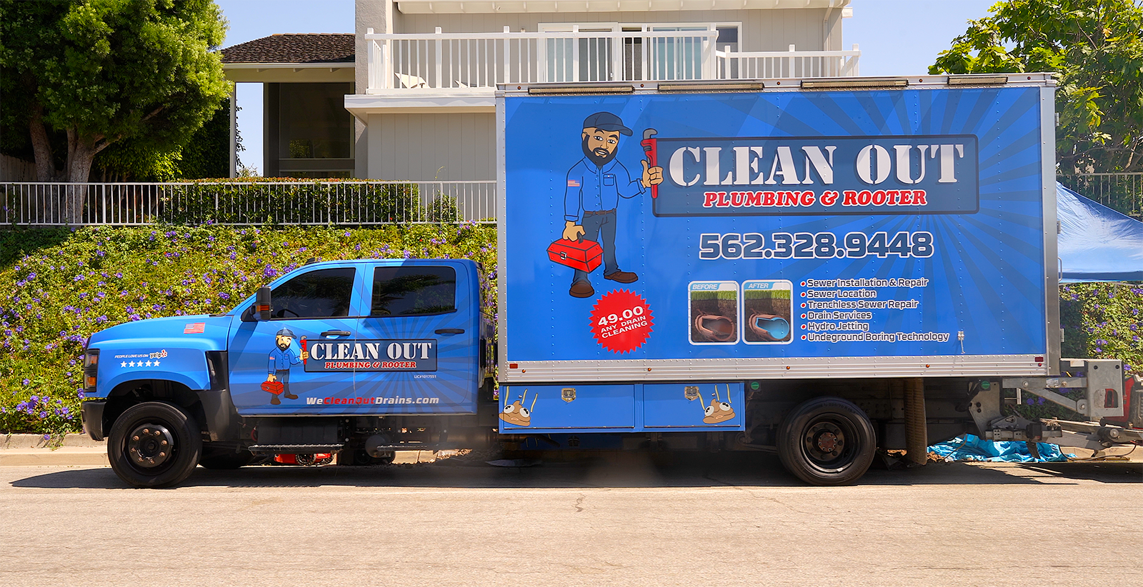 A blue clean out truck is parked in front of a house.