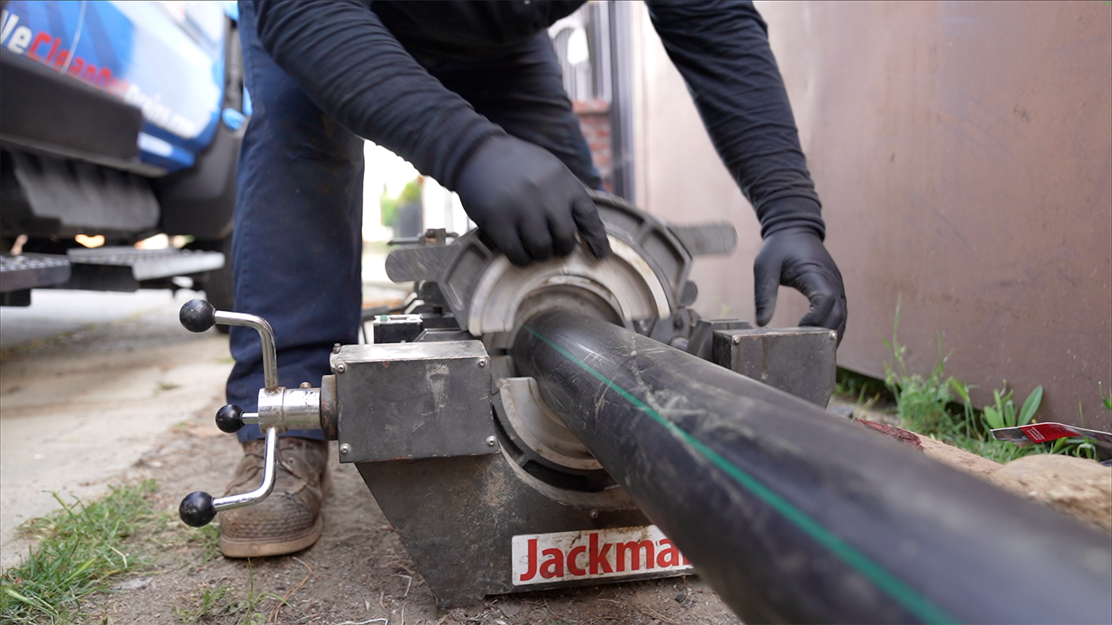 A man is working on a pipe with a machine.