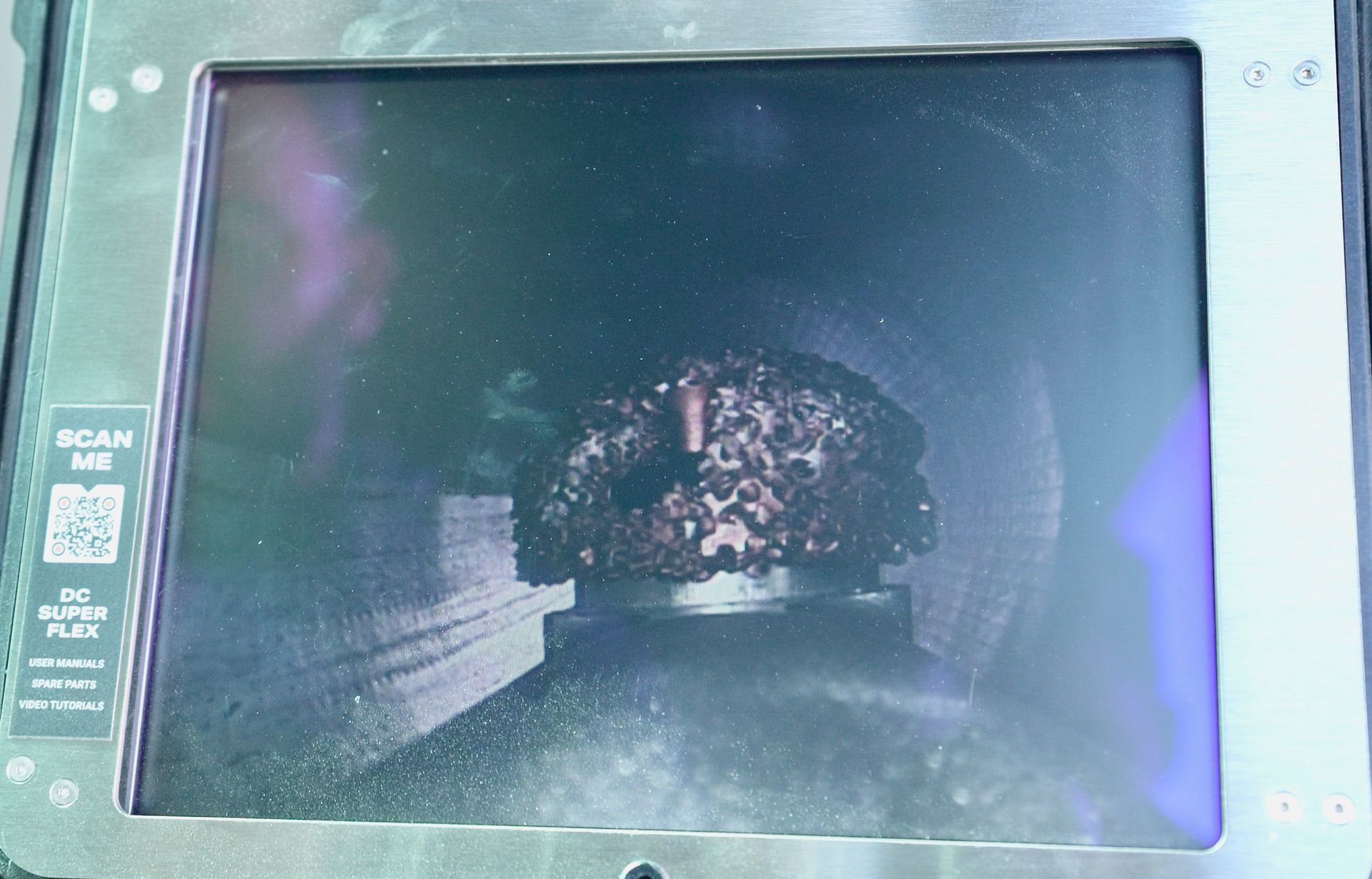 A computer screen shows a picture of a drain snake on it.