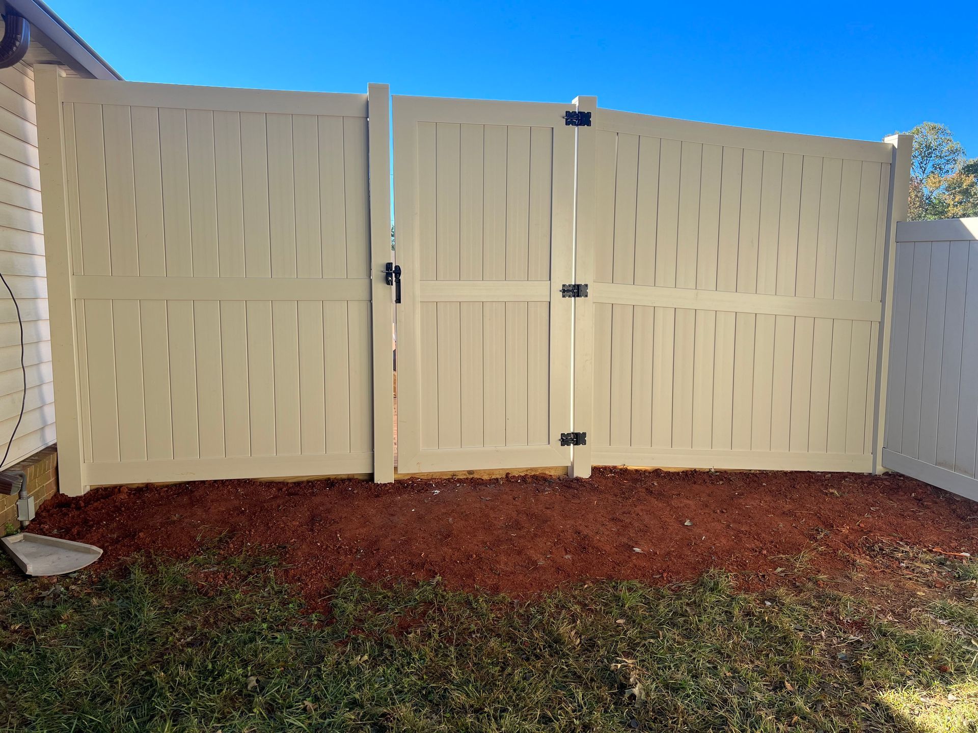 Cream vinyl fencing install back view