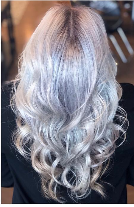 A woman with long gray hair is wearing a black shirt.