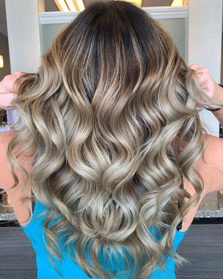 The back of a woman 's head with long wavy hair.