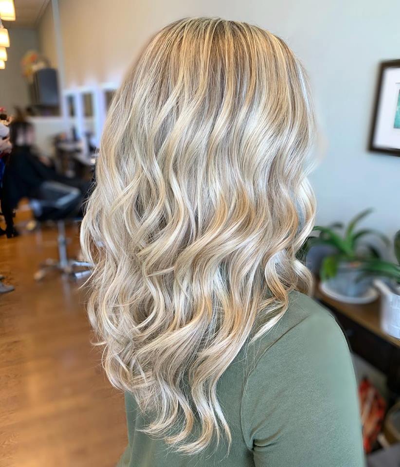 The woman is wearing a green shirt and has blonde hair.