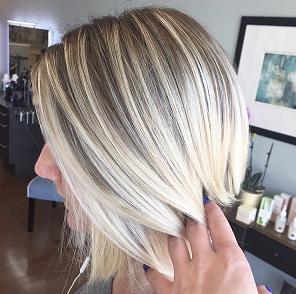A woman with blonde hair is getting her hair done in a salon.