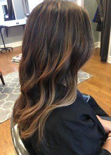 A woman is sitting in a chair with her hair in a salon.