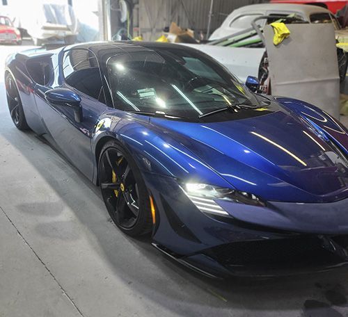 A blue sports car is parked in a garage