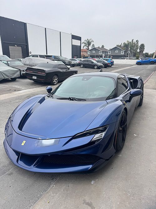 A blue sports car is parked in a parking lot.