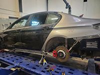 A car is being towed by a tow truck in a garage.