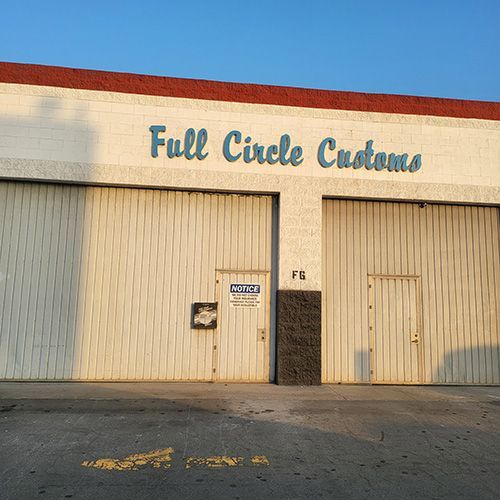 A full circle customs building with two garage doors