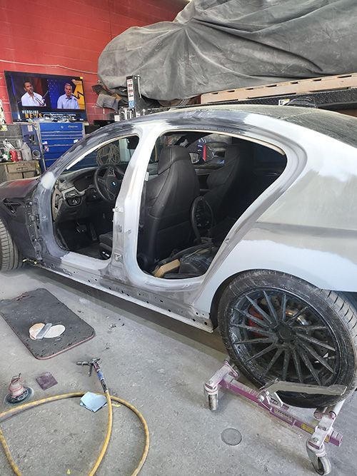 A car is being built in a garage with the door open.