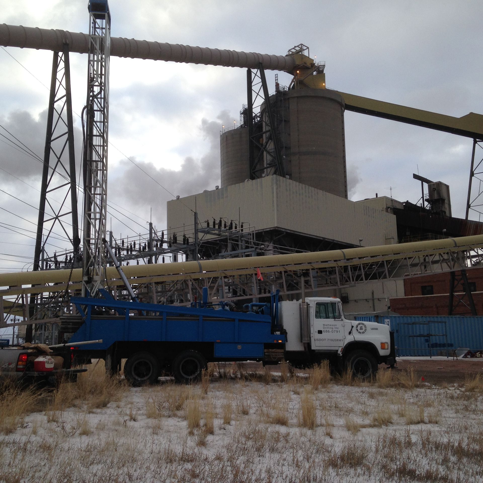 A blue truck is parked in front of a large building