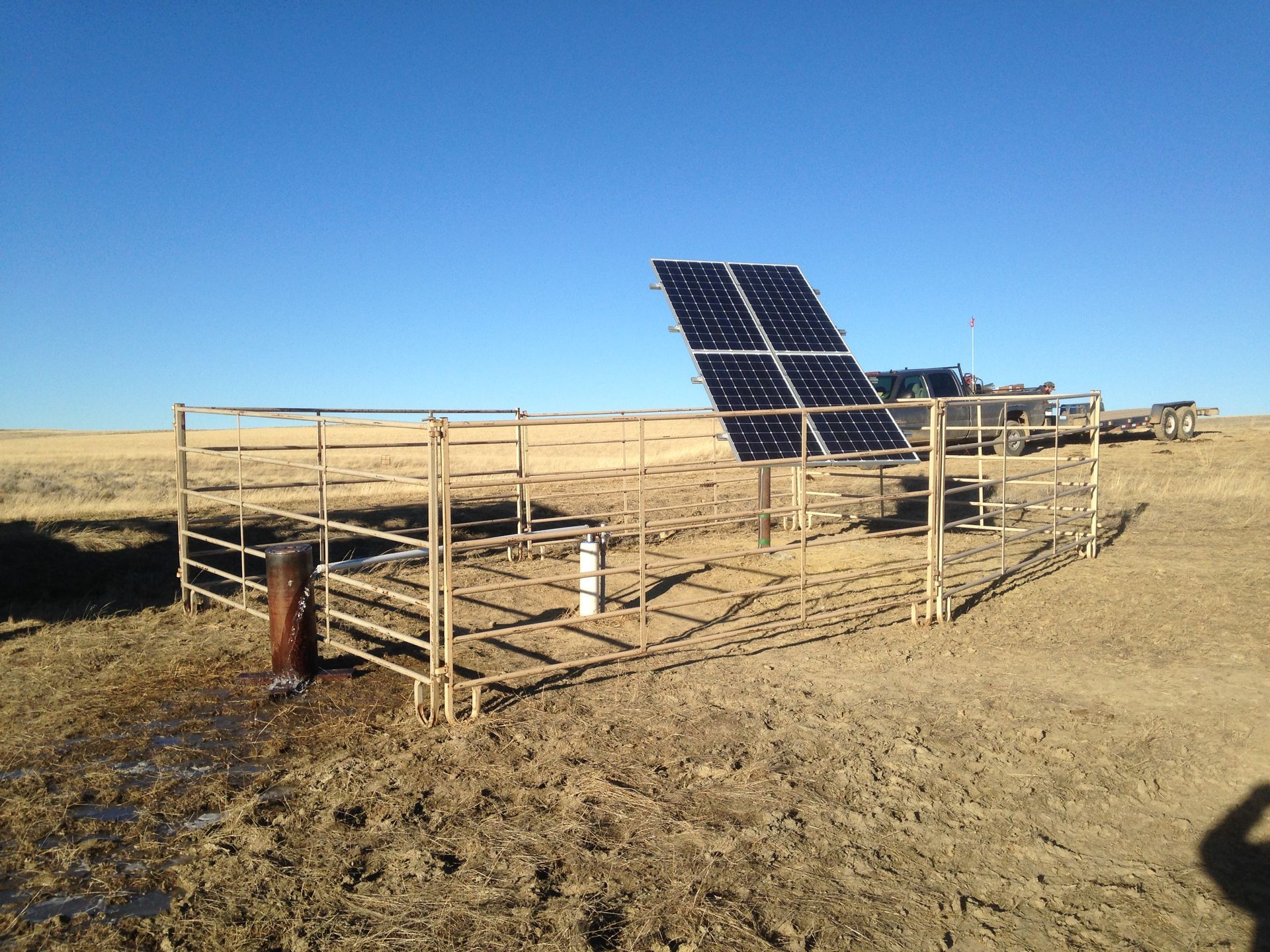 A solar panel is sitting in the middle of a dirt field