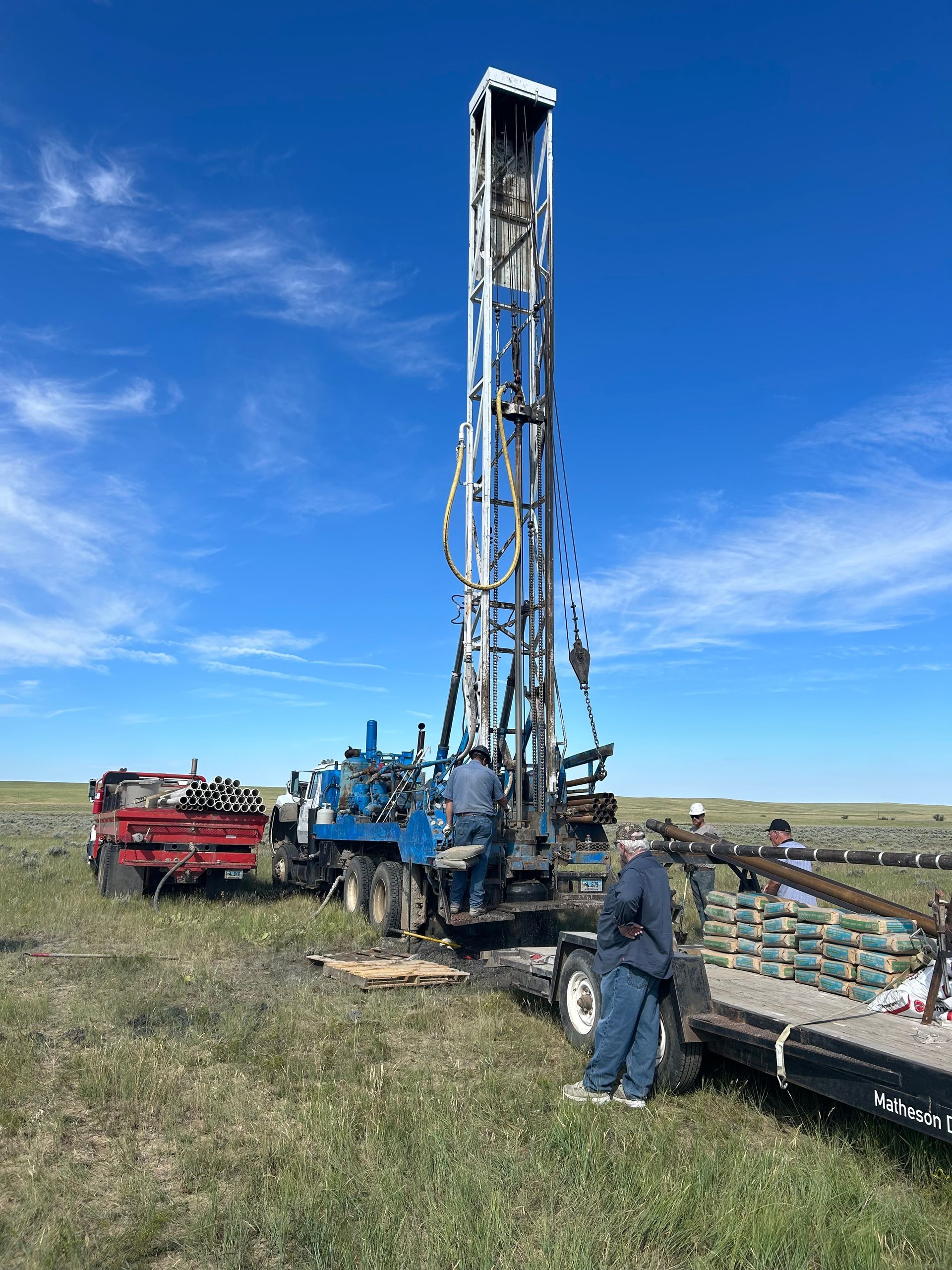A man is standing in front of a large machine in a field.