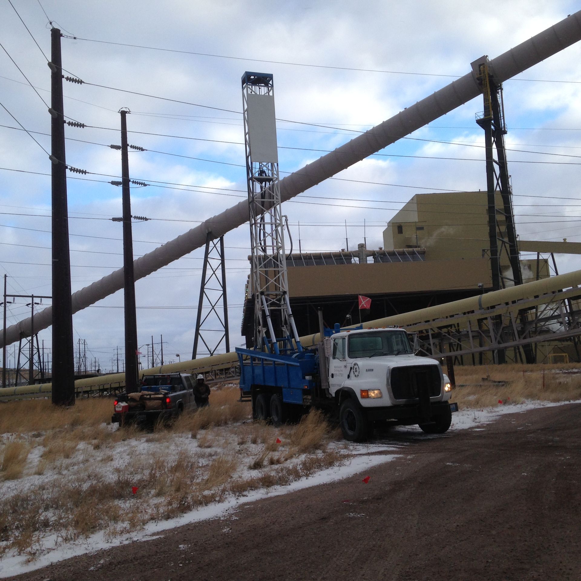 A blue and white truck is parked on the side of the road