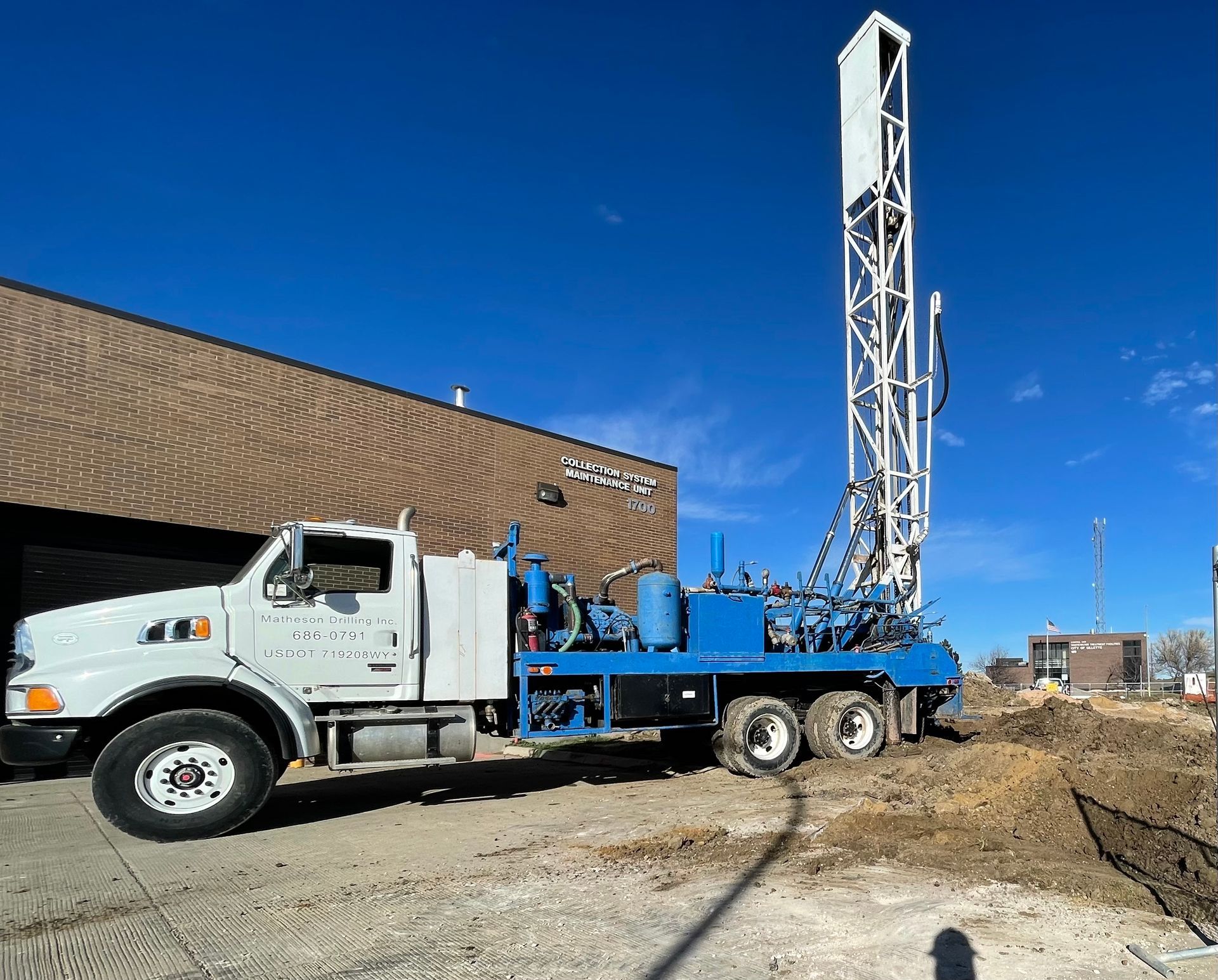A blue and white truck is parked in front of a building