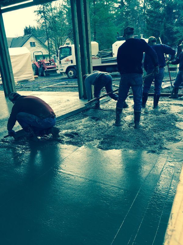 A group of men are working on a concrete floor