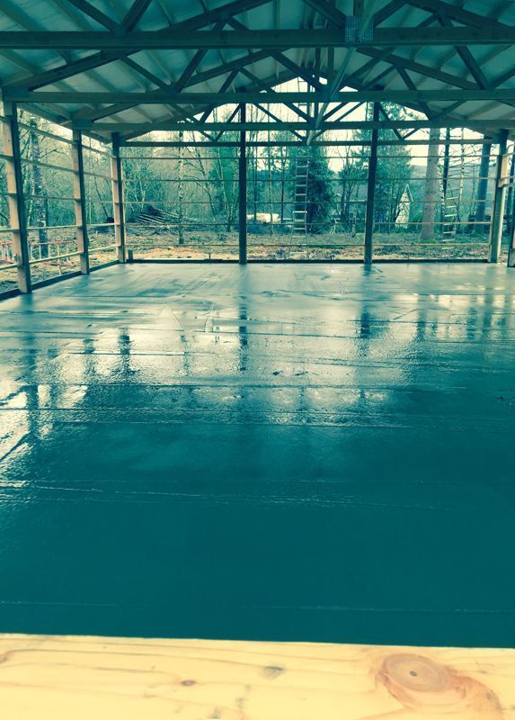 A large room with a concrete floor and a wooden ceiling.