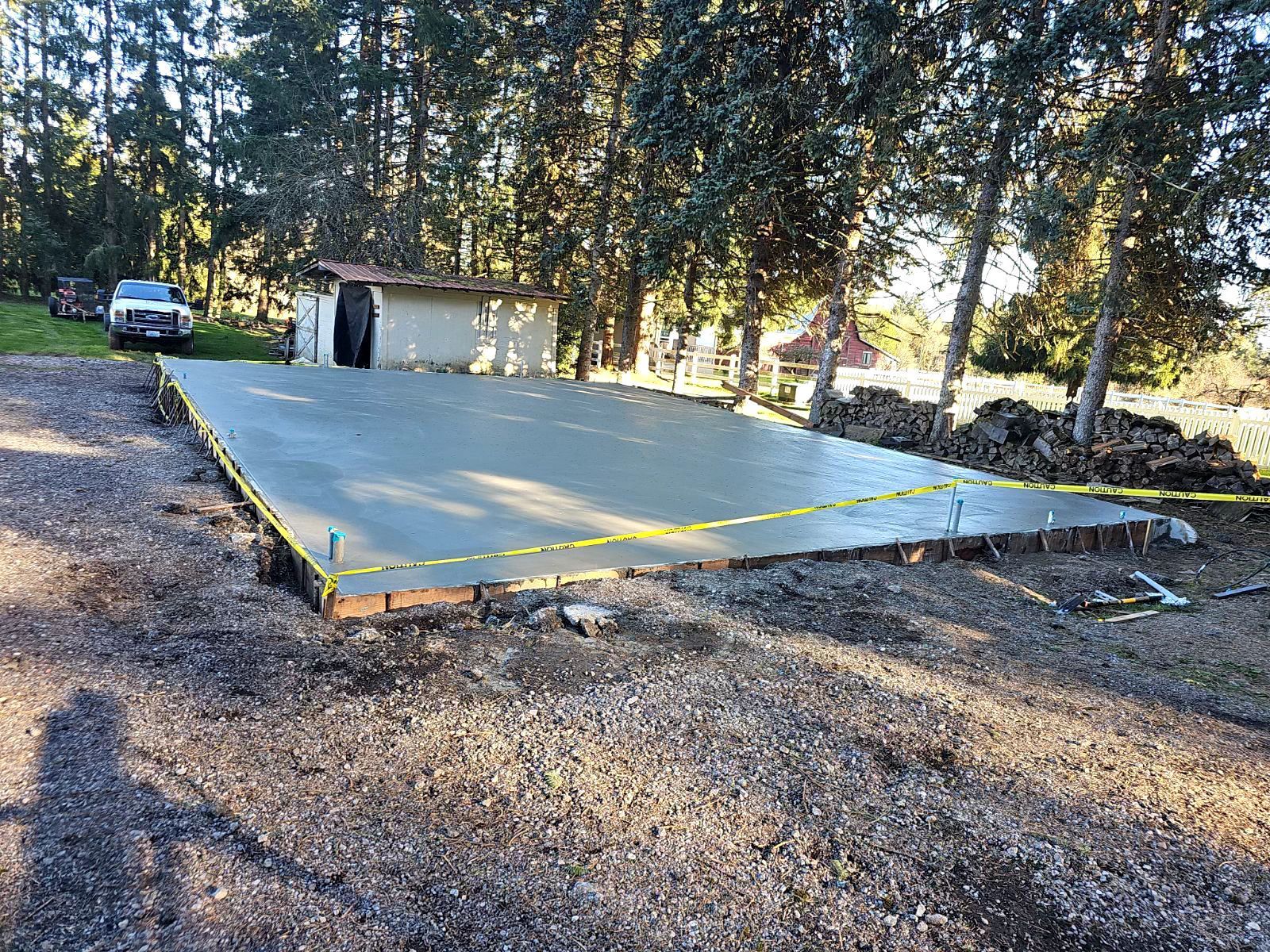 A concrete driveway is being built in front of a house.