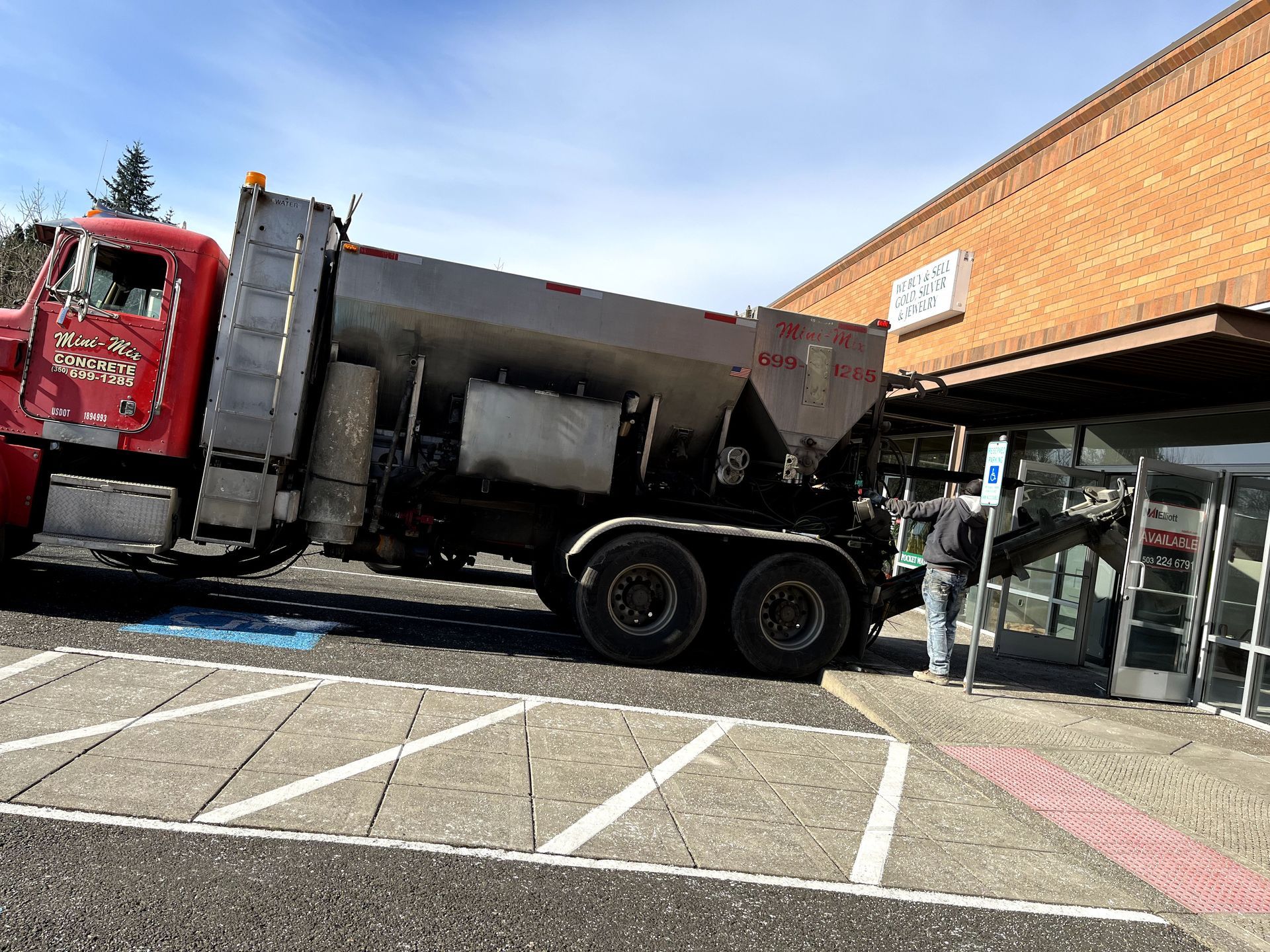 A large truck is parked in front of a brick building.
