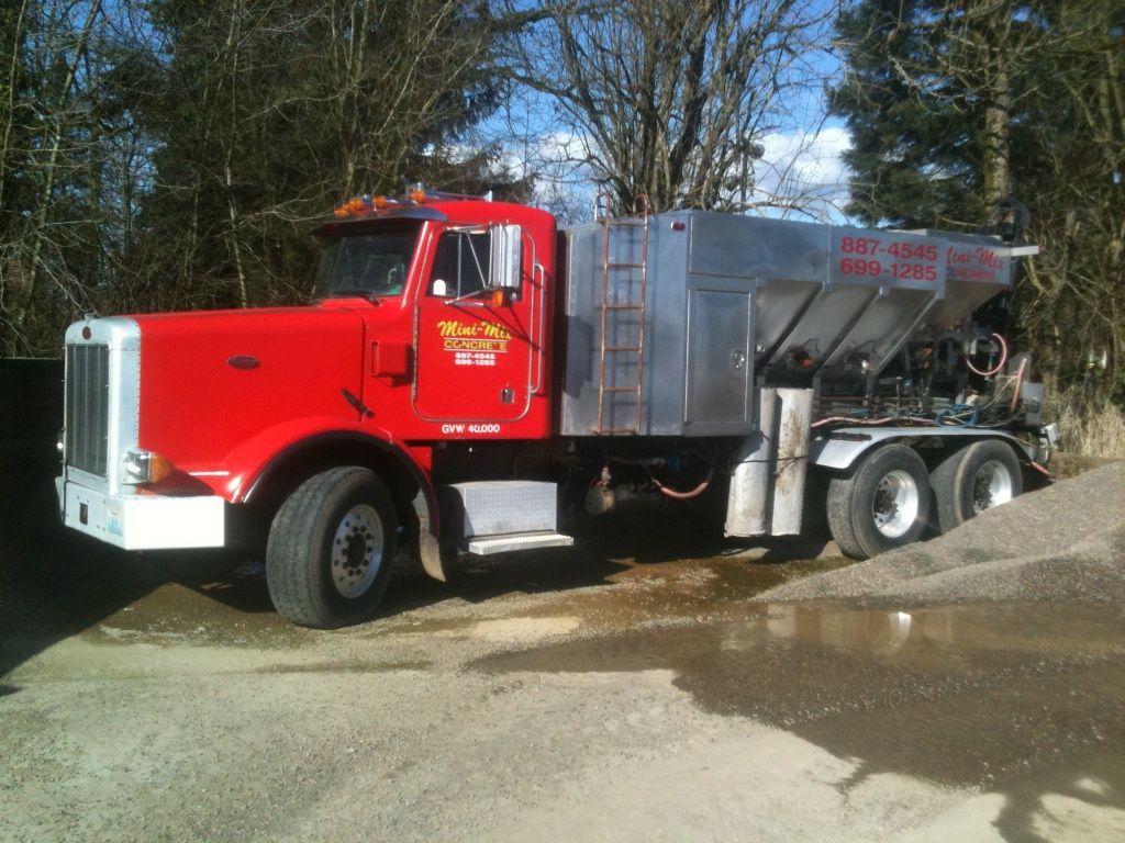 A red and silver truck with a sign on the side that says ' ray ' on it