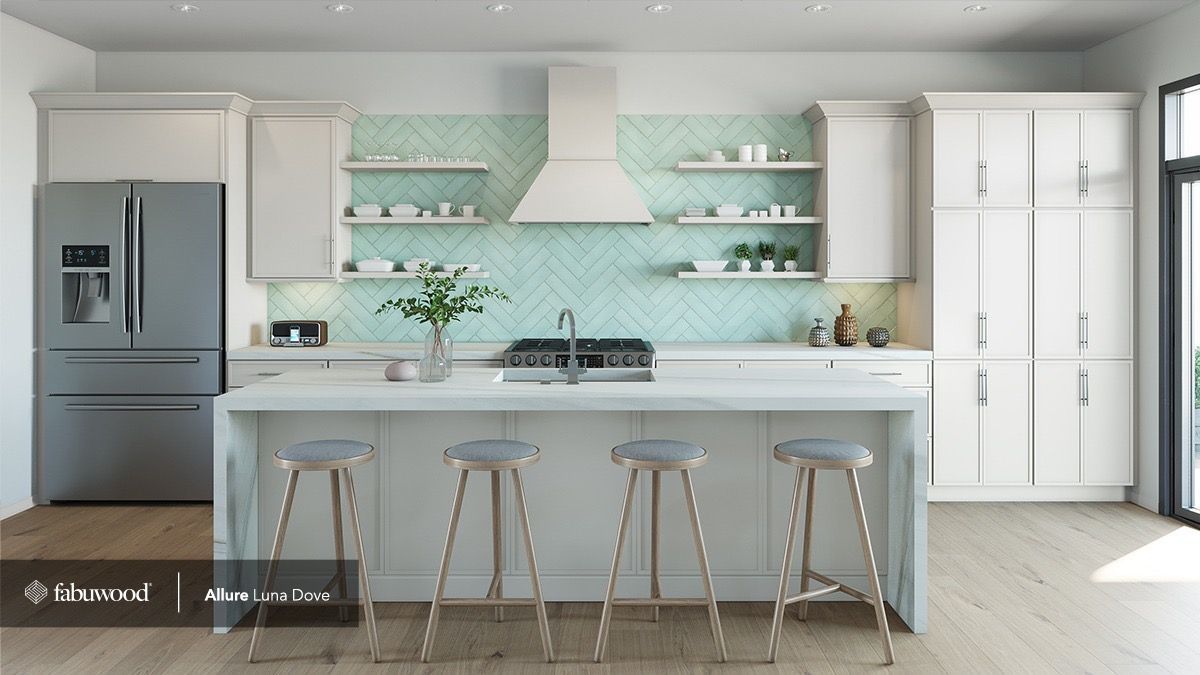 A modern kitchen featuring white cabinets, a light blue herringbone backsplash, stainless steel appliances, and an island.