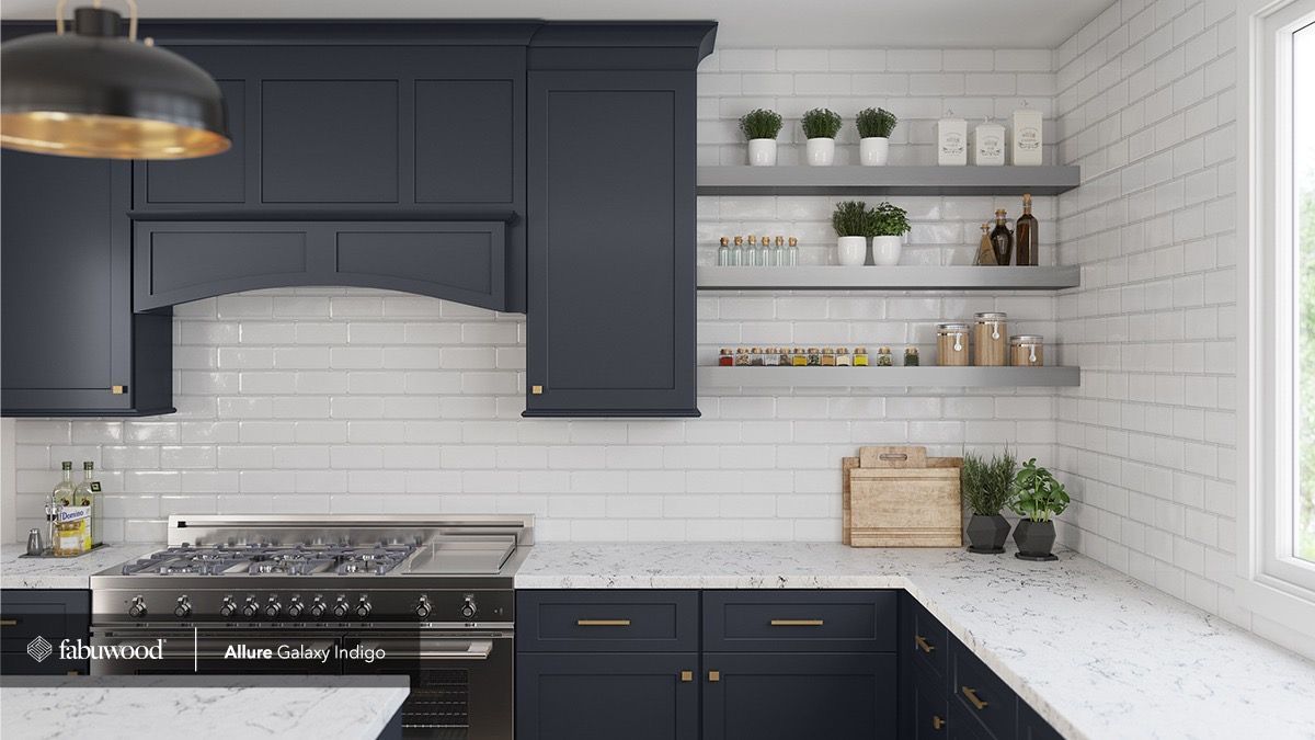 A modern kitchen features navy blue cabinets, marble countertops, white subway tile backsplash, and open wooden shelving.