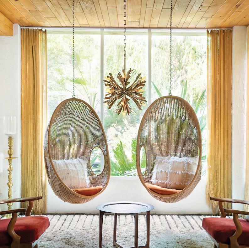 A living room with two hanging chairs and a table