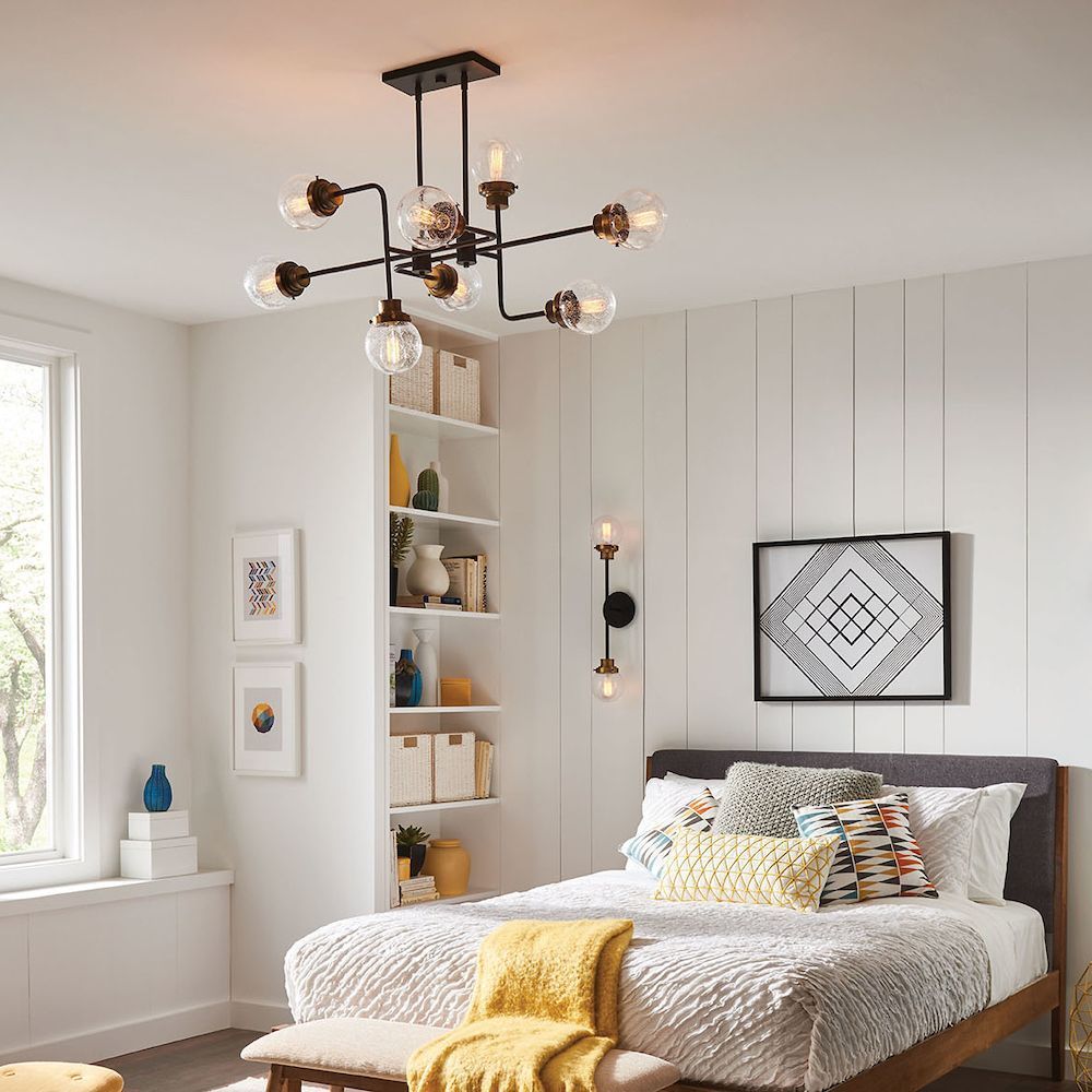 A bedroom with a bed and a chandelier hanging from the ceiling.