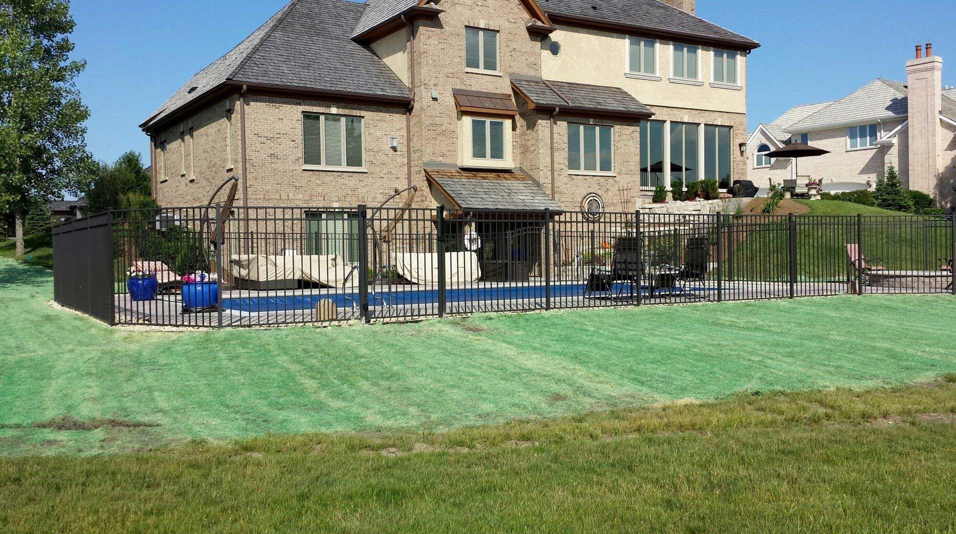 A large house with a pool and a fence around it.
