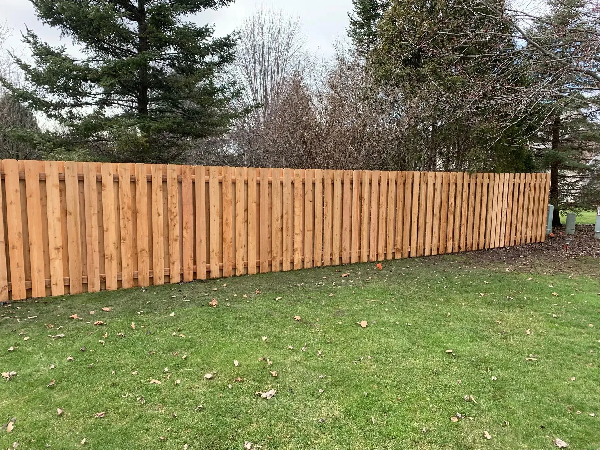 A wooden fence is sitting on top of a lush green lawn.