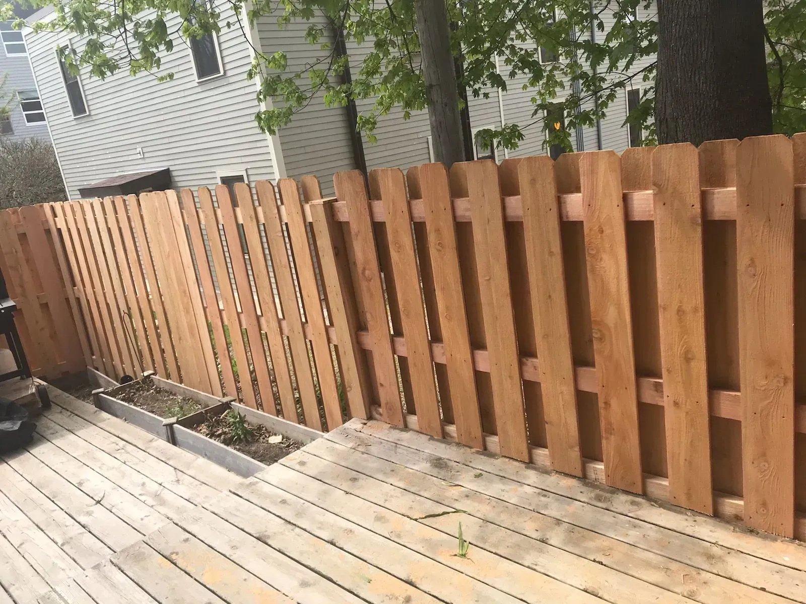 A wooden fence is sitting on top of a wooden deck.