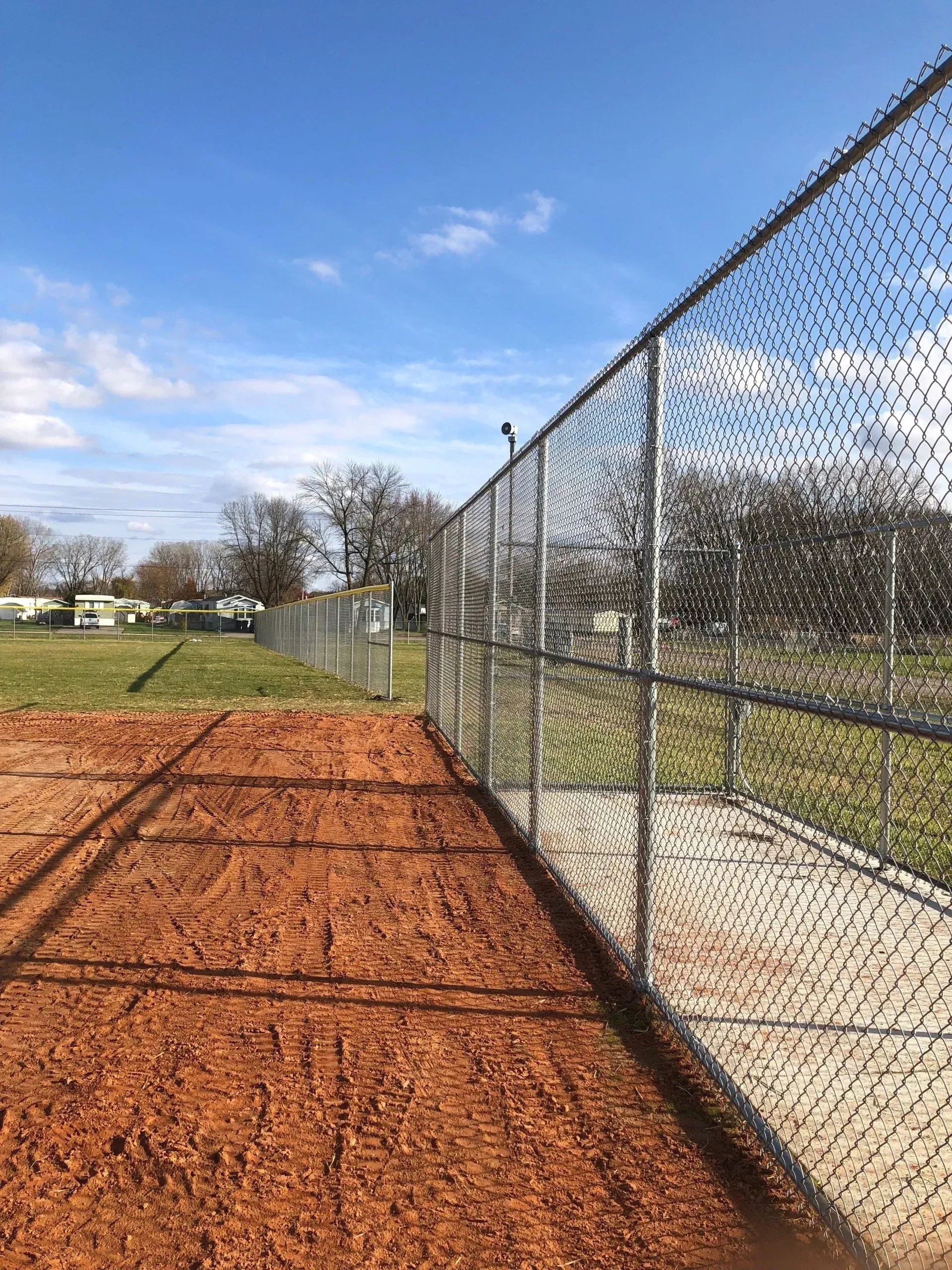 A chain link fence surrounds a baseball field.