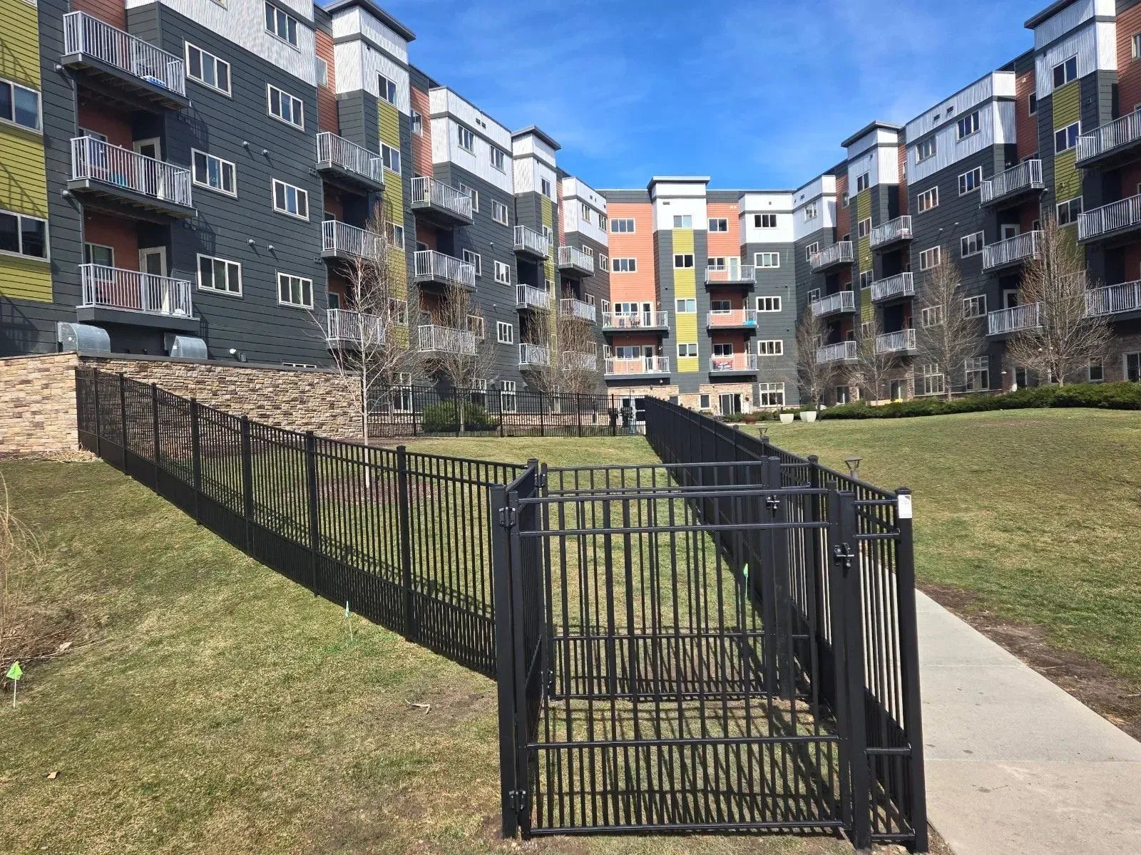 A large apartment building with a fence in front of it.