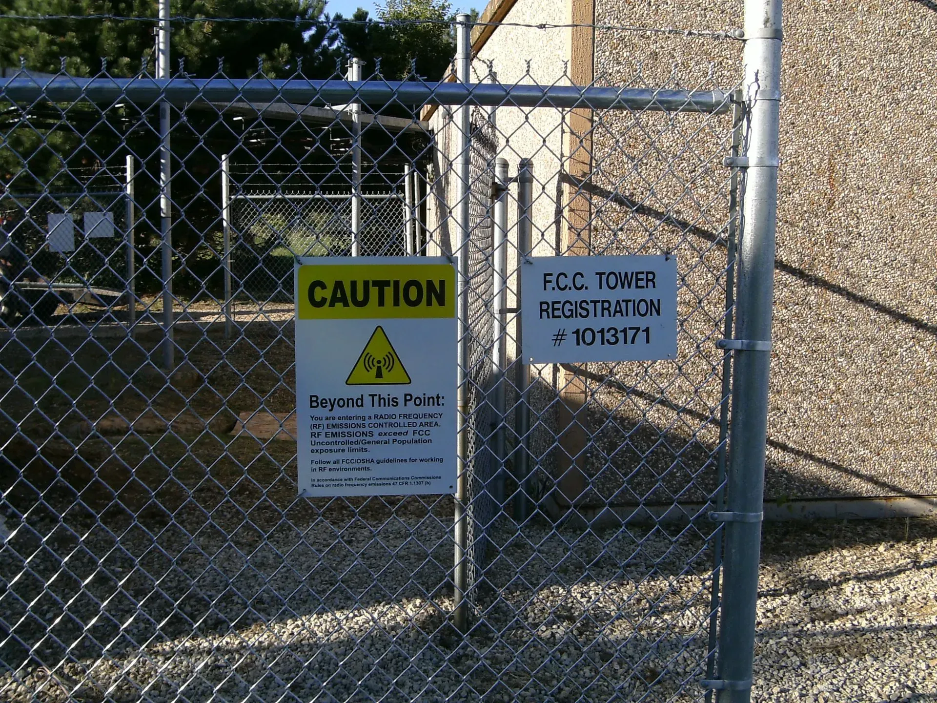 A chain link fence with a caution sign on it